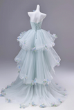 Light blue evening gown with floral details on a mannequin against a gray background