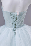 Light blue dress with intricate back design on a mannequin against a gray background