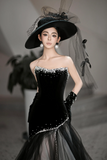 Woman wearing a black dress with white embellishments and a matching hat.