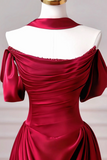 Red satin evening gown on a mannequin with a plain background
