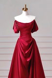 Red off-shoulder evening gown on a mannequin against a neutral background