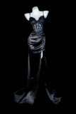 Black evening gown on a mannequin against a black background