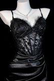 Black evening gown with sequin details on a mannequin against a black background