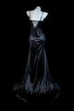 Black satin evening gown on a mannequin against a black background