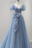 Blue evening gown with a bow on a mannequin against a gray background