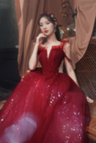Woman in a red dress sitting indoors with curtains in the background