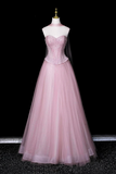 Pink evening gown on a mannequin against a black background