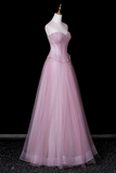Pink evening gown on a mannequin against a black background