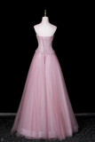 Pink evening gown on a mannequin against a black background