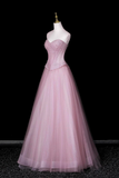 Pink evening gown on a mannequin against a black background