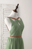 Green dress with brown accents on a mannequin against a white background