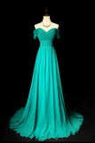 Teal evening gown on a mannequin against a black background