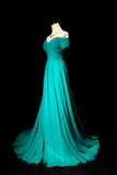 Teal evening gown on a mannequin against a black background