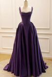Purple evening gown on a mannequin against a white wall.