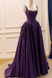Purple evening gown on a mannequin against a white wall.