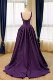 Purple evening gown on a mannequin against a window with curtains