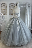 Gray ball gown with floral details on a mannequin in a decorative room.