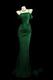 Green evening gown on a mannequin against a black background