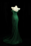Green evening gown on a mannequin against a black background