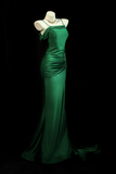 Green evening gown on a mannequin against a black background