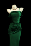 Green evening gown on a mannequin against a black background