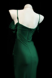 Green evening gown on a mannequin against a black background
