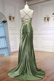Green evening gown on a mannequin against a white wall.