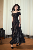 Woman wearing a black off-shoulder dress in an indoor setting