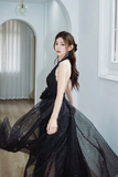 Woman in a black dress standing in an elegant interior setting