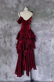 Red evening gown on a mannequin against a textured gray wall
