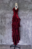 Red velvet dress on a mannequin against a textured gray wall