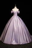 Purple ball gown on a mannequin against a black background