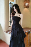 Woman in a black evening gown standing indoors.