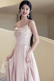 Woman in a light pink dress posing indoors with a neutral background