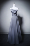 Gray strapless evening gown on a mannequin against a gray background