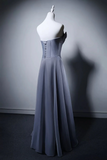 Gray evening gown on a mannequin against a gray background