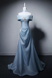 Blue evening gown on a mannequin against a gray background