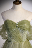 Green evening gown on a mannequin against a neutral background