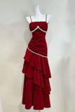 Red evening gown with ruffled layers on a mannequin against a white background