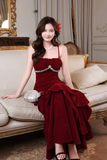 Woman in a red dress sitting on a couch in an elegant room.