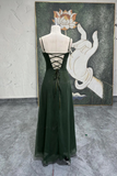 Green dress on a mannequin with a painting in the background