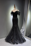 Black evening gown on a mannequin against a gray background