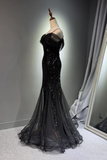 Black sequined evening gown on a mannequin against a gray wall.