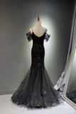 Black evening gown on a mannequin against a gray background