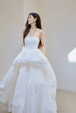 Woman in a white strapless gown with a plain background