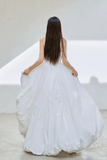 Woman in a white dress standing in a minimalistic room