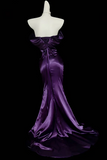 Purple evening gown on a mannequin against a black background
