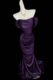 Purple evening gown on a mannequin against a black background