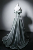Elegant silver evening gown on a mannequin against a dark background