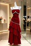 Red evening gown with white embellishments on a mannequin in a store setting.